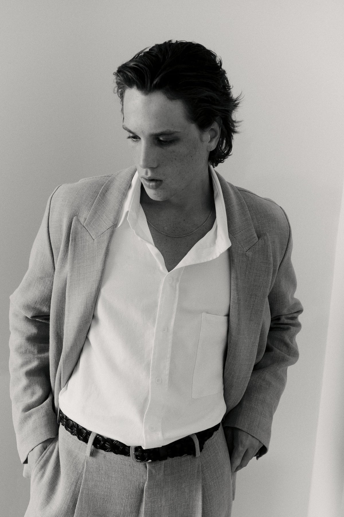 Black and white portrait of a model wearing a blazer and open collar shirt